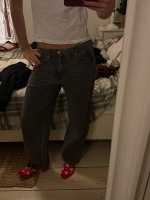 Grå loose fit jeans från Perfect Jeans - Säljer ett par grå jeans från Perfect Jeans i storlek 38. De har en loose fit med raka ben och klassisk femficksmodell. Jeansen är midwaist och tillverkade i ett mjukt bomullsmaterial som känns sköna hela dagen.