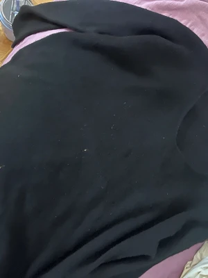 Svart basic tröjja i bomull - En enkel svart tröjja i mjukt bomullsmaterial. Modellen är klassisk med rund hals och korta ärmar, perfekt för en chill och avslappnad stil. Passar dig som gillar minimalistiska plagg och vill ha något som funkar till det mesta.