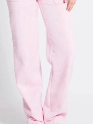 Rosa mjukisbyxor med snörning - Säljer ett par ljusrosa mjukisbyxor med breda ben och snörning i midjan. Byxorna har praktiska fickor framtill och en elastisk midja för skön passform. Perfekta för chill dagar och riktigt mjuka i materialet.