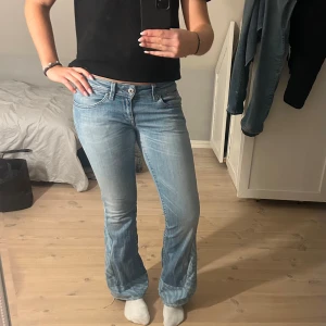 Lågmidjade bootcut jeans med zebramönster - Utsvängda med låg midja. Omsydda av ett UF-företag med zebra-jeanstyg. Ett litet hål mellan benen som är igensytt och syns ej när dom är på. Fina detaljer i fram och bak.