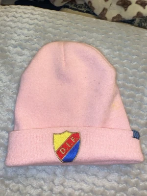 Vuxen mössa DIF djurgården - Haft på mig 2 ggrBilden visar en rosa mössa med DIF-emblem, snyggishhhhh