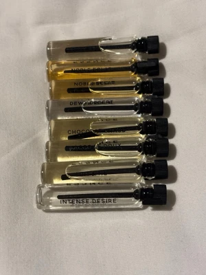 Parfymprov-set med 7 dofter - Upptäck sju olika dofter i smidiga provrör från Essence-Drunk apple pie, Intense desire, Suit & tie, Bacco le doux, Chocolat chaud, Dewy desert, Noble eclat (två st). Perfekt för dig som vill testa nya parfymer och hitta din favorit.