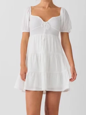 Vit kort klänning med puffärm - Superfin vit kort klänning från Bik Bok med puffärmar och söt knytning vid bysten. Klänningen har en omlottliknande v-ringad hals och volangdetaljer i kjolen. Materialet är mjukt och lätt, perfekt för studenten eller varma dagar! Prislappen är kvar 