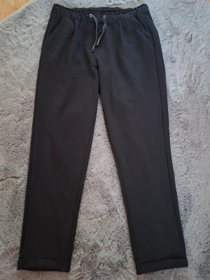 Svarta mjukisbyxor från Esmara - Svarta mjukisbyxor från Esmara med elastisk midja och snörning framtill. Byxorna har en rak passform och är tillverkade i mjukt material som känns skönt mot huden. Perfekta för chill dagar eller när du vill vara extra bekväm.