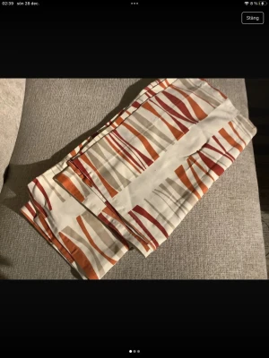 Panellängder  - Panellängder med ett coolt randigt mönster i orange, rött, beige och vitt. 