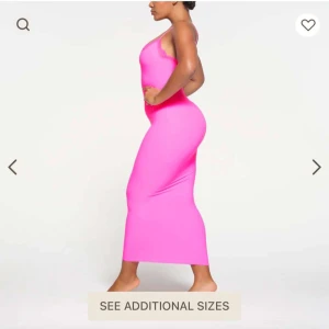 Rosa långklänning med spetskant - Lappen sitter kvar! Supersnygg långklänning i starkt rosa med smala axelband och spetsdetalj vid urringningen. Klänningen är figurnära och har en enkel, stilren design som verkligen sticker ut. Perfekt för dig som vill ha en färgklick i garderoben!