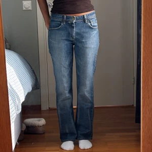 Levi's 627 Straight Fit blå jeans - Blå Levi's 627 Straight Fit jeans med klassisk femficksdesign, snygga slitningar och raka ben. Jeansen har normalhög midja, gul kontrastsöm och ikonisk läderpatch bak. Storlek står inte men uppskattar dem till XS-S