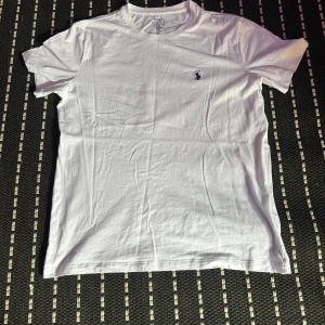 Vit t-shirt Polo Ralph Lauren - Vit t-shirt från Polo Ralph Lauren i slim fit med klassisk rund hals och liten broderad logga på bröstet. Tillverkad i mjuk bomull, perfekt för en clean och stilren look.