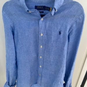 Blå linneskjorta från Polo Ralph Lauren - Snygg blå skjorta från Polo Ralph Lauren i linne med klassisk krage och knappar framtill. Den är i XS och passar dig runt 175. Skriv vid minsta fundering 🙌🙌