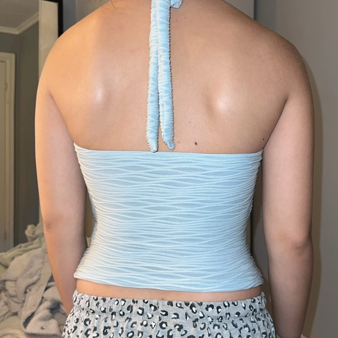 Ljusblå halterneck topp med blomdetalj