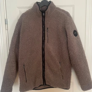 Brun teddyjacka med dragkedja från Snoot  - Teddyjacka med fleece material på insidan. Enbart några gånger och säljer pga bytt stil 