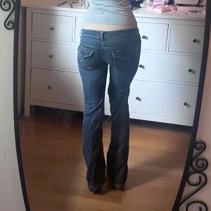 Blå bootcut jeans - Snygga blå jeans med bootcut passform och låg midja. jag har sytt om dom för att vara lågmidjade så dom sitter riktigt lågt. midjemåttet är 41cm tvärs över och jag är 174cm