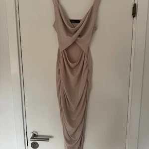 Beige långklänning från SHEIN - Supersnygg beige långklänning från SHEIN med breda axelband och draperad framsida. Klänningen har ribbat tyg och en cool omlott-detalj framtill som ger en unik look. 