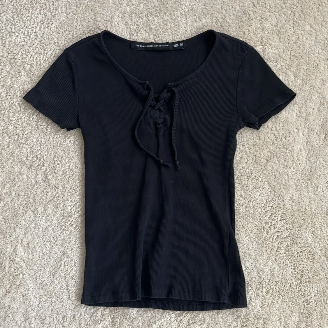 Svart ribbad topp med snörning