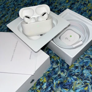 AirPods Pro - Säljer ett par Apple AirPods Pro i originalförpackning med laddningskabel och manual. Hörlurarna och laddningsetuiet ser ut att vara i gott skick utan synliga repor eller skador. Perfekt för trådlös musik och samtal med aktiv brusreducering och hög ljudkvalitet.
