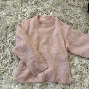 Ljusrosa stickad tröja Gina Tricot - Supermysig ljusrosa stickad tröja från Gina Tricot. Tröjan har rund halsringning, breda ribbade muddar vid ärmslut och nederkant samt lång ärm. Perfekt för lager-på-lager under kyliga dagar.