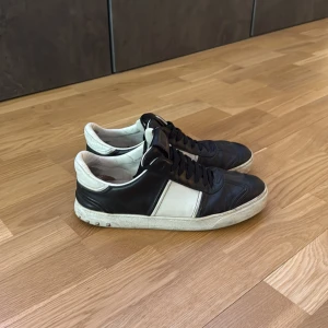 Valentino flycrew - Svartvita Valentino flycrew i skinn med klassisk låg profil och snörning. Snygg kontrast mellan svart och vitt, samt diskreta nitar baktill på sulan för en extra edge. Extremt eftertraktade och snygga! Säljer de då de blivit för små!
