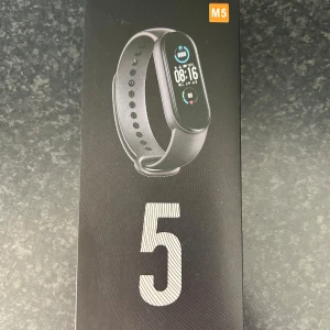 Smart träningsklocka Mi Band 5 - Xiaomi Mi Band 5 aktivitetsarmband med färgdisplay, pulsmätare och stegräknare. Perfekt för träning och hälsa, med lång batteritid och vattentålig design. Produkten ser ut att vara i nyskick, förpackningen är obruten och utan synliga skador.