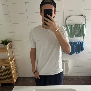 Vit t-shirt från Axel Arigato  - Vit t-shirt från Arigato med tryck fram och bak. Klassisk rund hals och med skön passform. Riktigt bra kvalité.