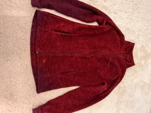 Vinröd fleecejacka från Everest - Mysig vinröd fleecejacka från Everest med hel dragkedja och två sidofickor. Jackan har en enkel, sportig design och är perfekt för kyliga dagar. Materialet är mjukt och värmande, och passformen är normal med långa ärmar.