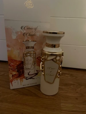 Crème of Clouds Eau de Parfum - Crème of Clouds från Fragrance World är en Eau de Parfum med lyxig design. Tillverkad i U.A.E. Perfekt för dig som vill sticka ut med en unik flaska och modern känsla. säljer för ja inte tyckte om doften den är helt ny men när ja skulle öppna och lukta så råka ja riva sönder paketet vilket man ser på sista bilden!