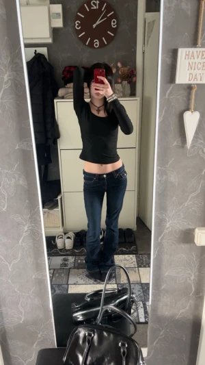 Mörkblå bootcut jeans True Religion - Säljer ett par mörkblå bootcut jeans från True Religion med snygga kontrastsömmar och ikoniska fickdetaljer bak. Låg midja och klassisk femficksmodell. Jeansen är i stretchigt denim och har silver och guldfärgade knappar och nitar.  defektera syns inte när jeansen är på