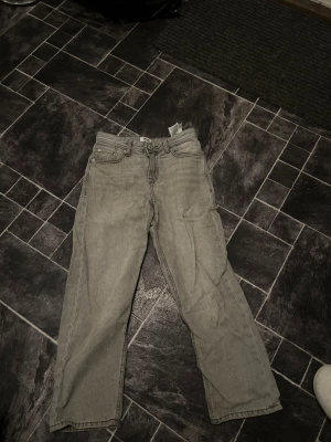 Grå jeans från Jack & Jones, stl 146 - Säljer ett par grå jeans från Jack & Jones i storlek 146. Klassisk femficksmodell med raka ben och normal passform. Jeansen är tillverkade i bomull och har en snygg, ljusgrå tvätt som passar till det mesta. Perfekta för dig som gillar en enkel och stilren look.
