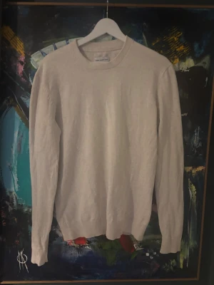 Beige stickad tröja These Glory Days - En stilren beige stickad tröja från These Glory Days i storlek small. Tröjan har rund hals, ribbade muddar och långärmad passform. Perfekt för dig som gillar enkel och clean look med mjukt material.