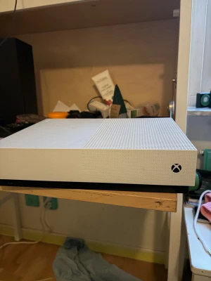 Xbox One S - Snygg Xbox One S i vit färg. Konsolen är i gott skick med endast mindre ytliga märken, inga synliga större repor eller skador. Perfekt för gaming och streaming. Kompakt design och tyst drift. Levereras utan tillbehör.