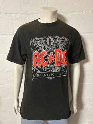 T-shirt med ACDC brun/svart melerad XL - Helt ny T-shirt med ACDC. Storlek XL. Brun/svart melerad,
