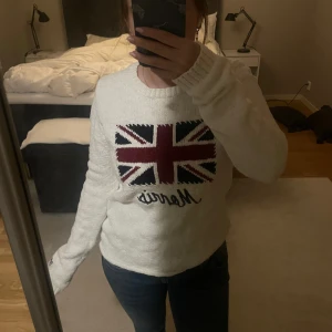 Vit stickat Morris Lady S tröja - Säljer en vit stickad tröja från Morris Lady i storlek S. Tröjan har ett stort Union Jack-motiv i rött, blått och vitt på bröstet samt broderad Morris-text under. Ribbstickade muddar och en liten svart broderad detalj på ärmen.                               