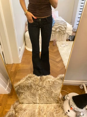 Bootcut jeans från Weekend  - Mörkblå bootcut jeans från Weekend med klassisk femficksdesign och kontrastsömmar. Snygg låg midja och stretchigt denimtyg som sitter skönt. Perfekt passform. Liten rosa logga bak på linningen. 32/25 ca 36 midjemått och 79 innerbenslängden. Passar mig som är en 34-Xs. Pris kan diskuteras!💓💓