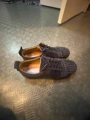 Mörkblå Louboutins - Blå Louboutin-sneakers, strl 43 Säljer ett par blå Louboutins. Ej originalsnören. Lätt slitna undertill men i gott skick i övrigt. Pris: bud. Kan skickas eller hämtas. Pris gpr att diskutera vid snabb affär. Skorna är äkta.