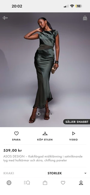 Khakigrön långklänning från ASOS DESIGN - Snygg khakigrön långklänning i satinliknande material med skira chiffongpaneler. Klänningen har holkärmar och en cool öppen rygg med knappdetalj upptill. Den har en figurnära passform och ett elegant fall som ger en lyxig vibe.