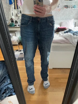Blå jeans från Lindex - Snygga blå baggy jeans från Lindex i klassisk femficksmodell med raka ben och normal passform. Jeansen har knapp och dragkedja framtill, samt bälteshällor. Materialet är slitstarkt denim i bomull och färgen är mörkblå med lätt tvättad look.