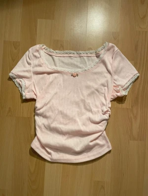 Ljusrosa topp med spets - Ljusrosa topp från SHEIN med korta ärmar och spetsdetaljer vid halsringning och ärmslut. 