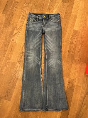 Blåa Bootcut jeans från Cheap Monday  -  Blåa Bootcut jeans från Cheap Monday med orange logga. Den oranga loggan är lite förstörd men inget som stör.