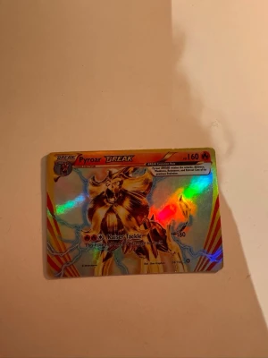 Pyroar BREAK Pokémonkort holo - Unikt samlarkort från Pokémon, Pyroar BREAK, med holografisk yta och guldfärgade detaljer. Kortet har en cool illustration av Pyroar och är en del av BREAK-serien. Perfekt för dig som vill utöka din samling med ett glittrande och speciellt kort. (Köpte den av en annan, den borde vara äkta men är inte 100% säker )
