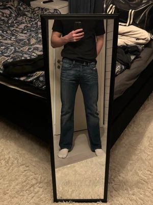 Blå Diesel Bootcut/Straight Jeans - Säljer ett par blå Diesel jeans med bootcut/Straight passform och snygga slitningar framtill samt under knäveck. Jeansen har klassisk femficksdesign, normal midja och är tillverkade i slitstarkt denim. Perfekta för dig som gillar en avslappnad men ändå stilren look. Storlek 31, skulle säga att de är som W32 eller W33. Sedan längd ungefär L32 eller L33.