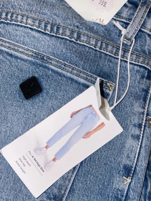 Abrand high waist straight jeans - Säljer ett par ljusblå high waist jeans med rak passform. Klassisk femficksmodell i mjukt bomullsjeansmaterial. Perfekta till sneakers eller boots och har en tidlös look.
