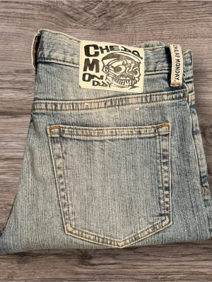 Cheap Monday ljusblå jeans 29/32 - Säljer ett par ljusblå jeans från Cheap Monday med klassisk femficksdesign och snyggt slitna detaljer. Jeansen har rak passform. Märkets ikoniska döskalle-logga på bakfickan  