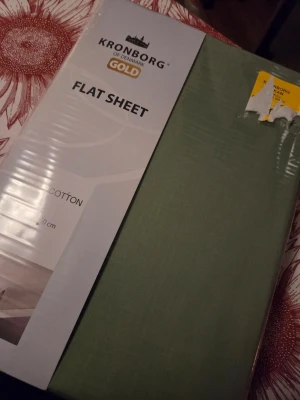 Grönt lakan Kronborg 240x260 cm - Säljer ett grönt flat sheet från Kronborg Gold, tillverkat i 100% bomull. Lakanet är stort och passar perfekt till dubbelsäng. Kommer i originalförpackning och har en mjuk, slät yta.