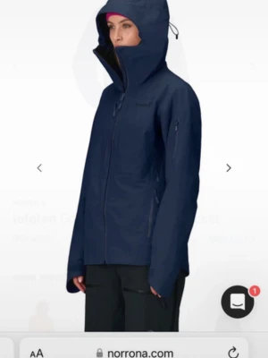 Mörkblå skaljacka från Norrøna, M - Säljer en mörkblå skaljacka i Lofoten kollektionen från Norrøna med huva och hel dragkedja framtill. Jackan har flera praktiska fickor med dragkedja och justerbar huva samt snölås. Den är även lite fodrad. 