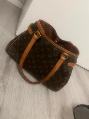 Louis Vuitton Monogram Batignolles Horizontal Tote Bag. - Säljer Louis Vuitton Monogram Batignolles Horizontal Tote Bag. Köpt den 31 december 2025 från ”A retro tale” vilket är ett företag som tar in begagnade vintage väskor och säljer vidare. Väskorna är noga inspekterade och kollade av experter för att kolla äktheten och dom säljer endast äkta väskor. Köpt för 7900kr.  Kvitto/orderbekräftelse finns även att kunna se. Säljer pga att det var för mycket pengar för mig att lägga på en väska just nu som jag inte riktigt insåg förens nu efter köpet…