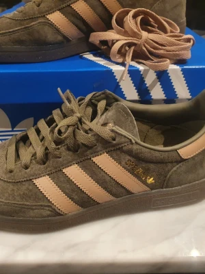 Adidas Spezial sneakers olivgrön/beige - Säljer ett par Adidas Spezial sneakers i olivgrönt mocka med klassiska beigea stripes på sidorna och matchande snörning. Köpta vid jul. KVITTO MEDFÖLJER.