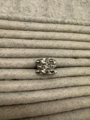 Silvrig ring med nitar - Super snygg ring med nitar från Edblad, storlek 16.00/xs. Håller på att byta alla smycken till guld därav säljer jag nu alla silver smycken jag har kvar:)