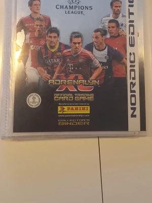 Panini Adrenalyn XL samlaralbum inklusive massor av kort - Samlaralbum för Panini Adrenalyn XL officiella trading cards, UEFA Champions League Nordic Edition. Albumet har färgglada omslag med fotbollsspelare och är tillverkat i plast. Perfekt för att organisera och visa upp dina fotbollskort. Om ni är intresserade av nån eller några permar så kan ni skriva så dkickar jag bilder på korten. Några permar är nästan helt fulla medan vissa är halv fulla. Pris kan diskuteras vid snabb affär. 