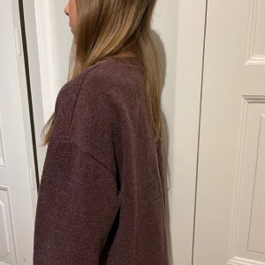 Mörk vinröd stickad tröja - Snygg, mörk vinröd stickad tröja med rund halsringning och långa ärmar. Har används få tal gånger då jag säljer den. 