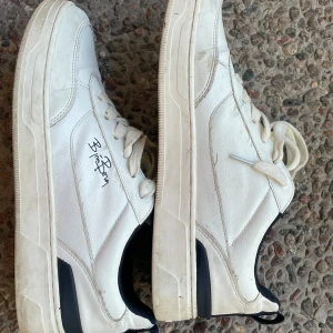 Vita sneakers från Björn Borg - Snygga vita sneakers från Björn Borg med mörkblå detalj på häl och plös. Skorna har klassisk snörning, rund tå och är tillverkade i syntetmaterial med textilfoder. Perfekta för en clean och sportig look. Väldigt bra skick och pris kan diskuteras 