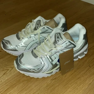 Asics Gel storlek 43 - Snygga Asics sneakers i vitt och silver. Säljer pågrund att dom var för små för mig. Aldrig använda.
